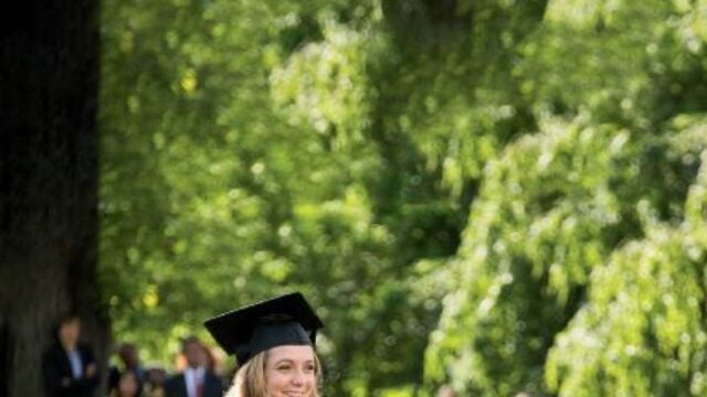 female student standing in graduation crowd