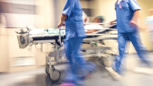 picture of doctors wheeling patient on bed thru hospital
