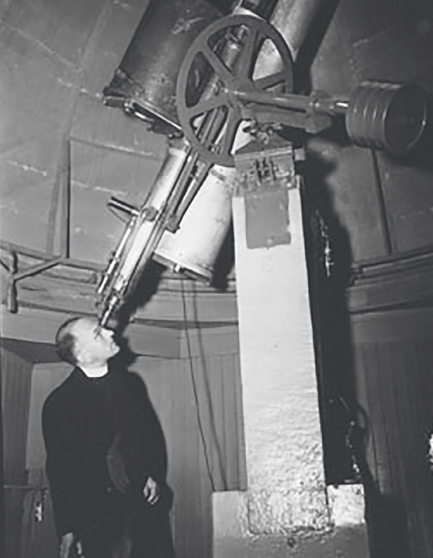 Director Francis J. Heyden, S.J., with the 1888 telescope, still in use