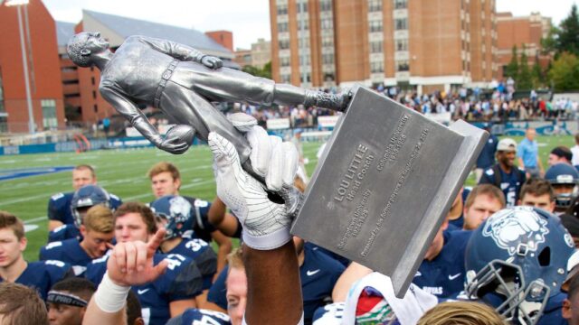 georgetown football players holding lou little trophy