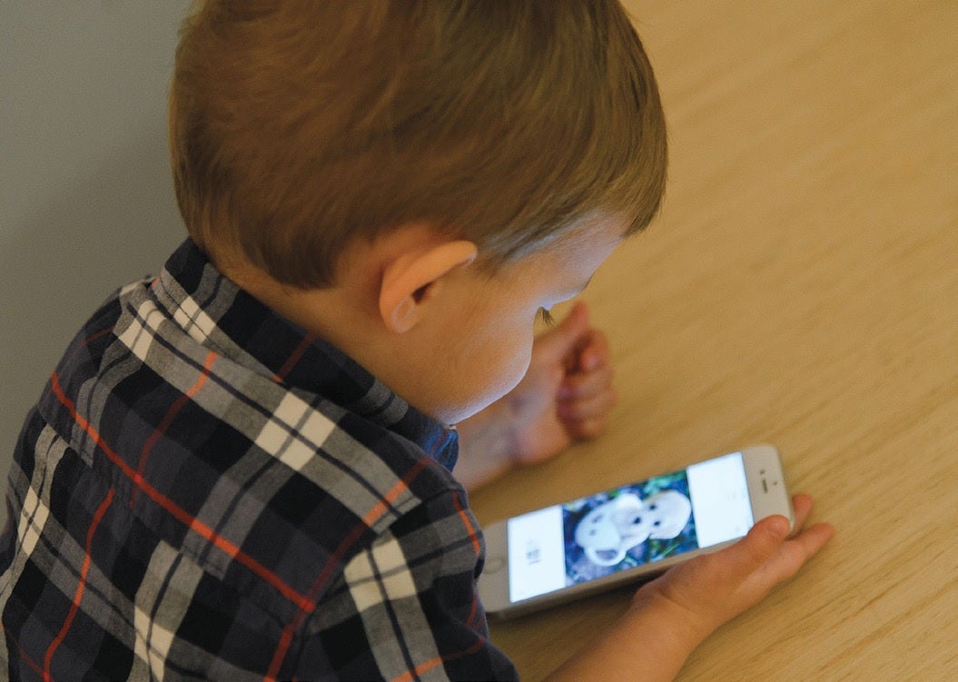 child is playing on an iPhone