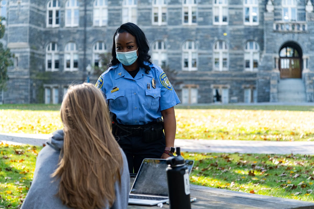 GUPD Sergeant Joyce Pearson makes time to speak with a student. All staff members comply with the Every Hoya Everywhere public health campaign by social distancing and wearing masks