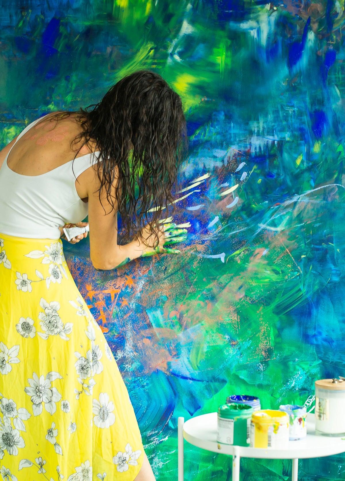 A woman in a yellow skirt paints