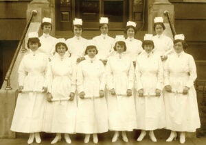 women in nursing uniforms stand in a group