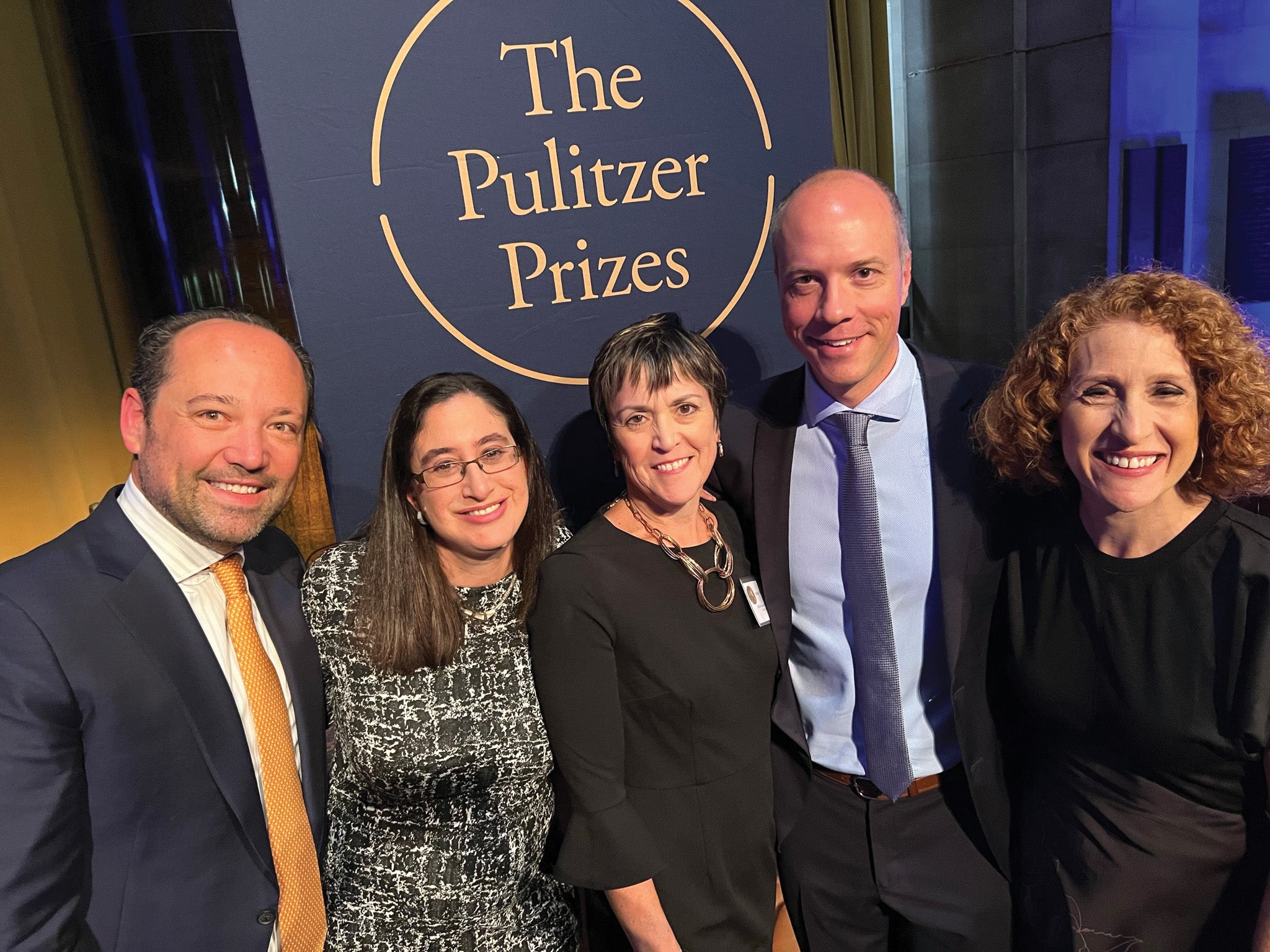 people stand in front of the Pulitzer Prize sign