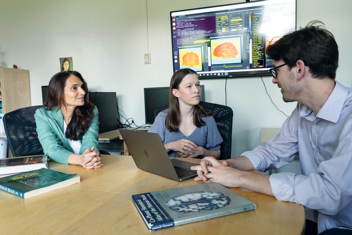 (Left to right) Psychology professor Chandan Vaidya, Ph.D., pre-med student Brenna Towell (C’23), and IPN graduate student Adam Kaminsky, Ph.D. (G’26) discuss a project involving the brain’s executive control and factors involving its physical and mental breakdown.