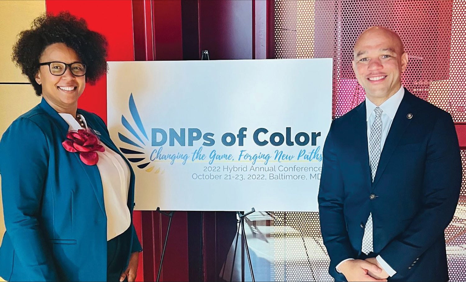 two people stand in front of a sign that says "DNPs of Color"