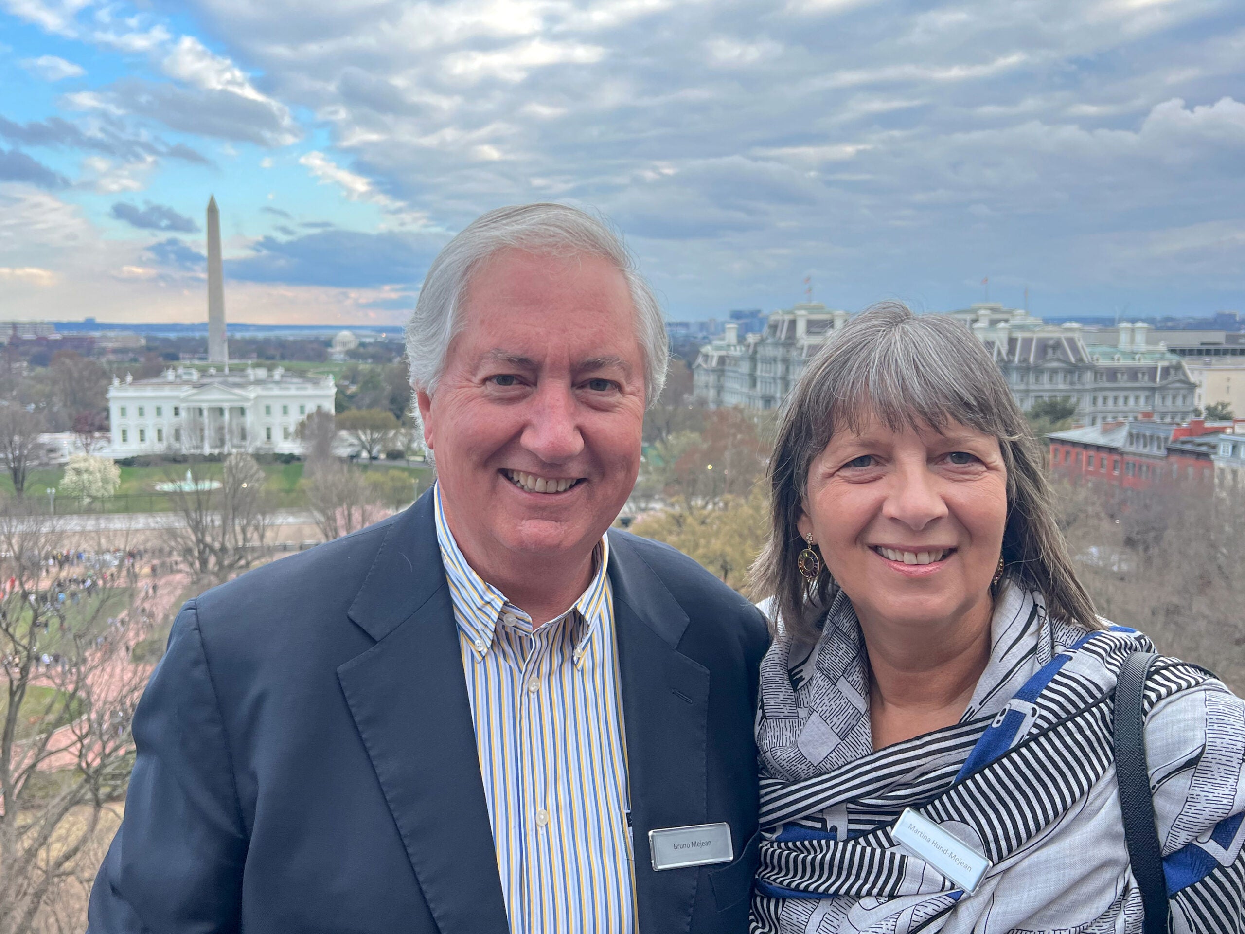 a man and a woman smile at the camera with the US Capitol in the background
