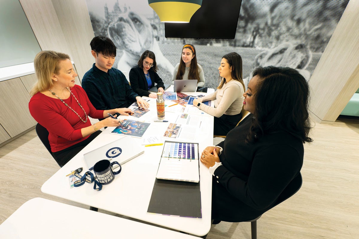 advancement staff talking and working around table