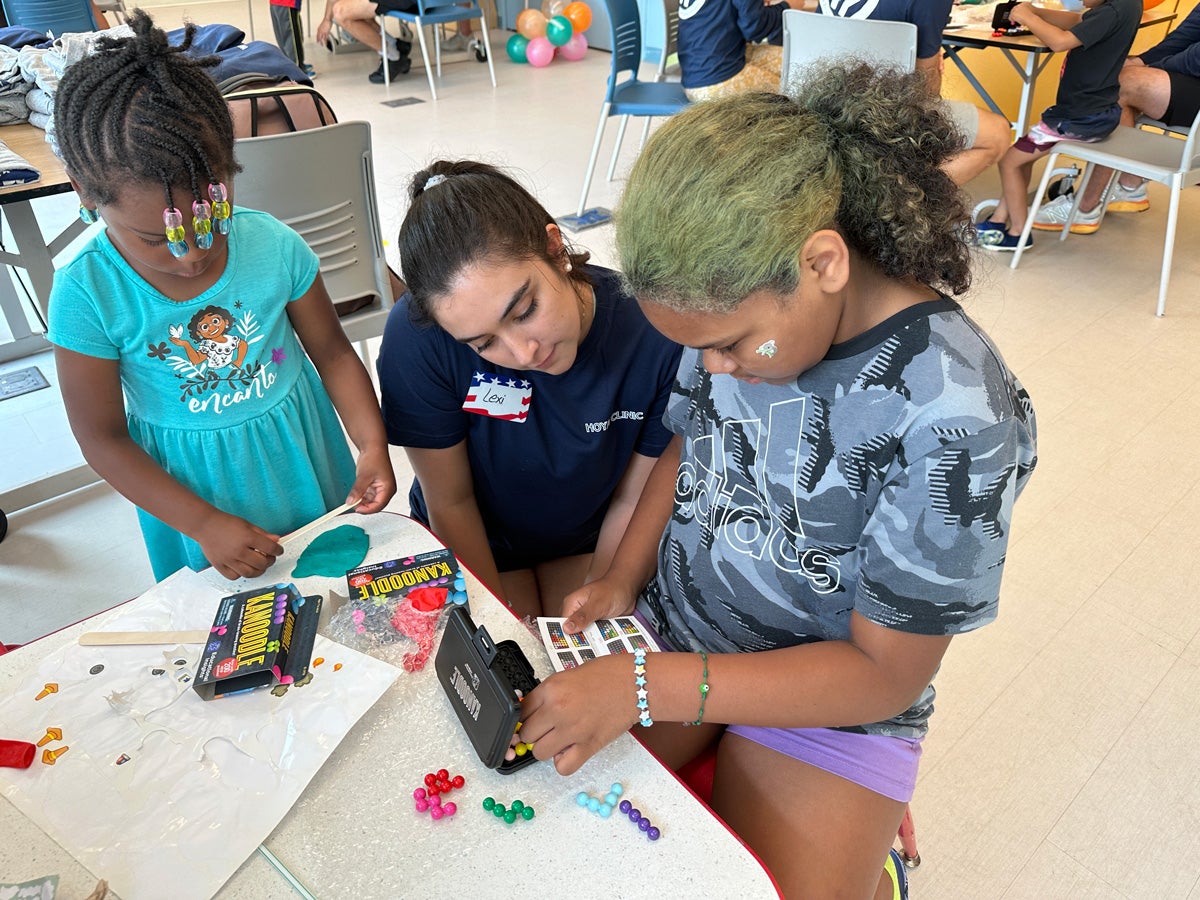 student with campers doing crafts