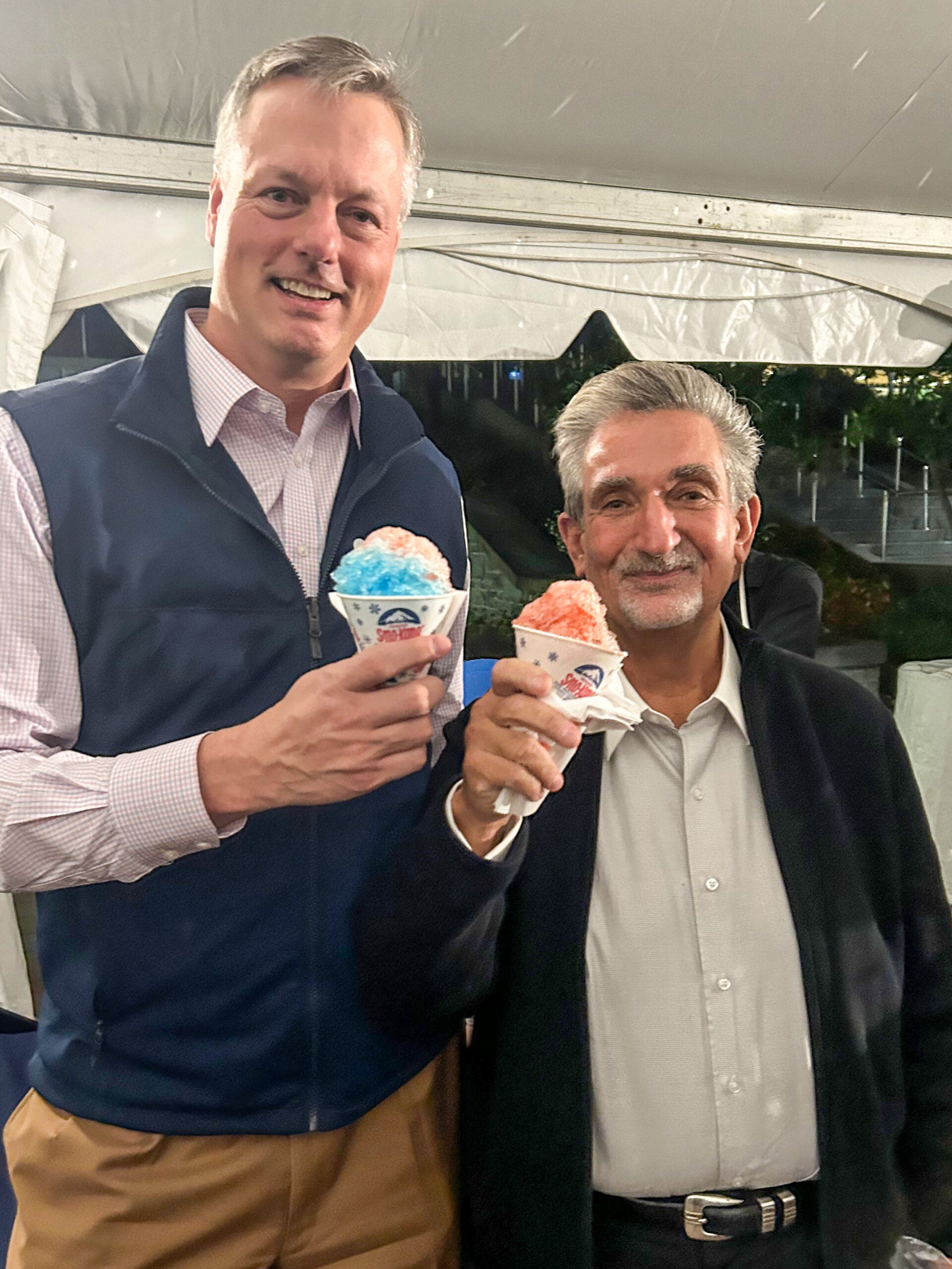 two men each hold a multicolored snow cone