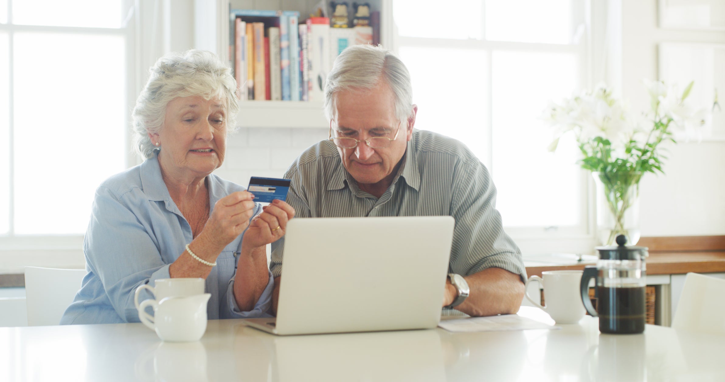 elderly people talking and working on laptop