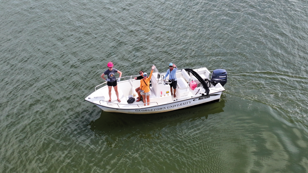 students waving from boat