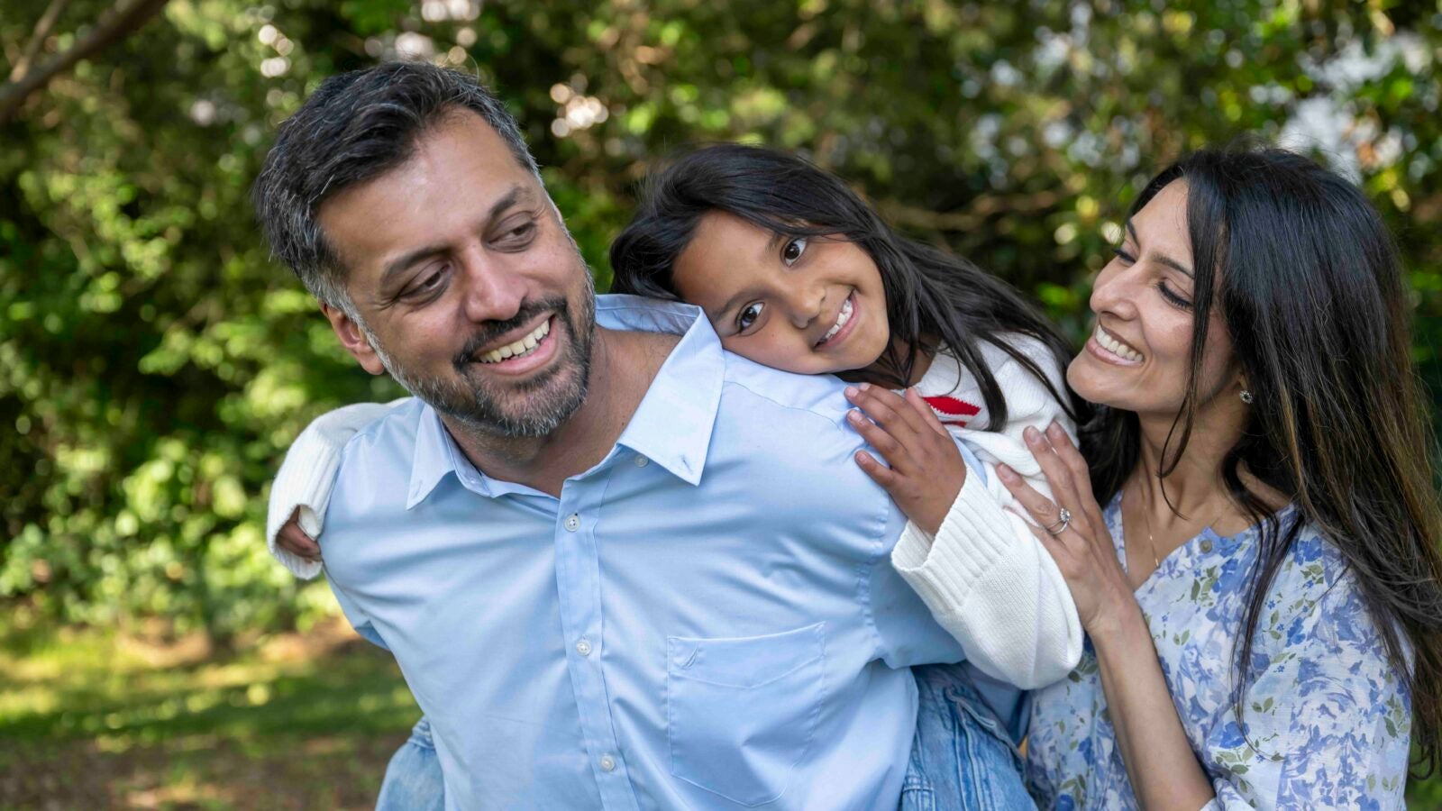two parents hug a child