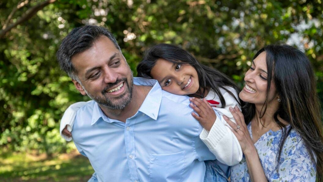 two parents hug a child
