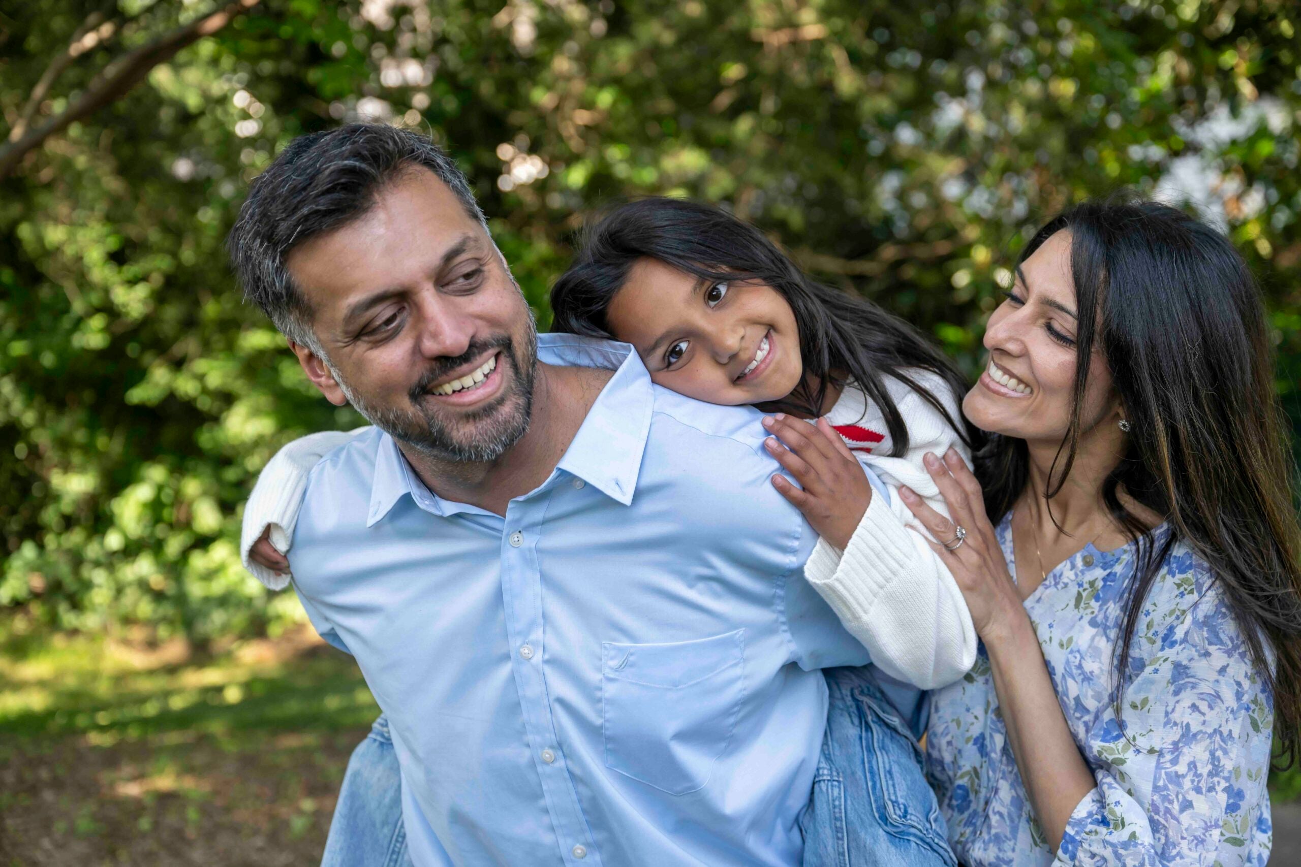 two parents hug a child