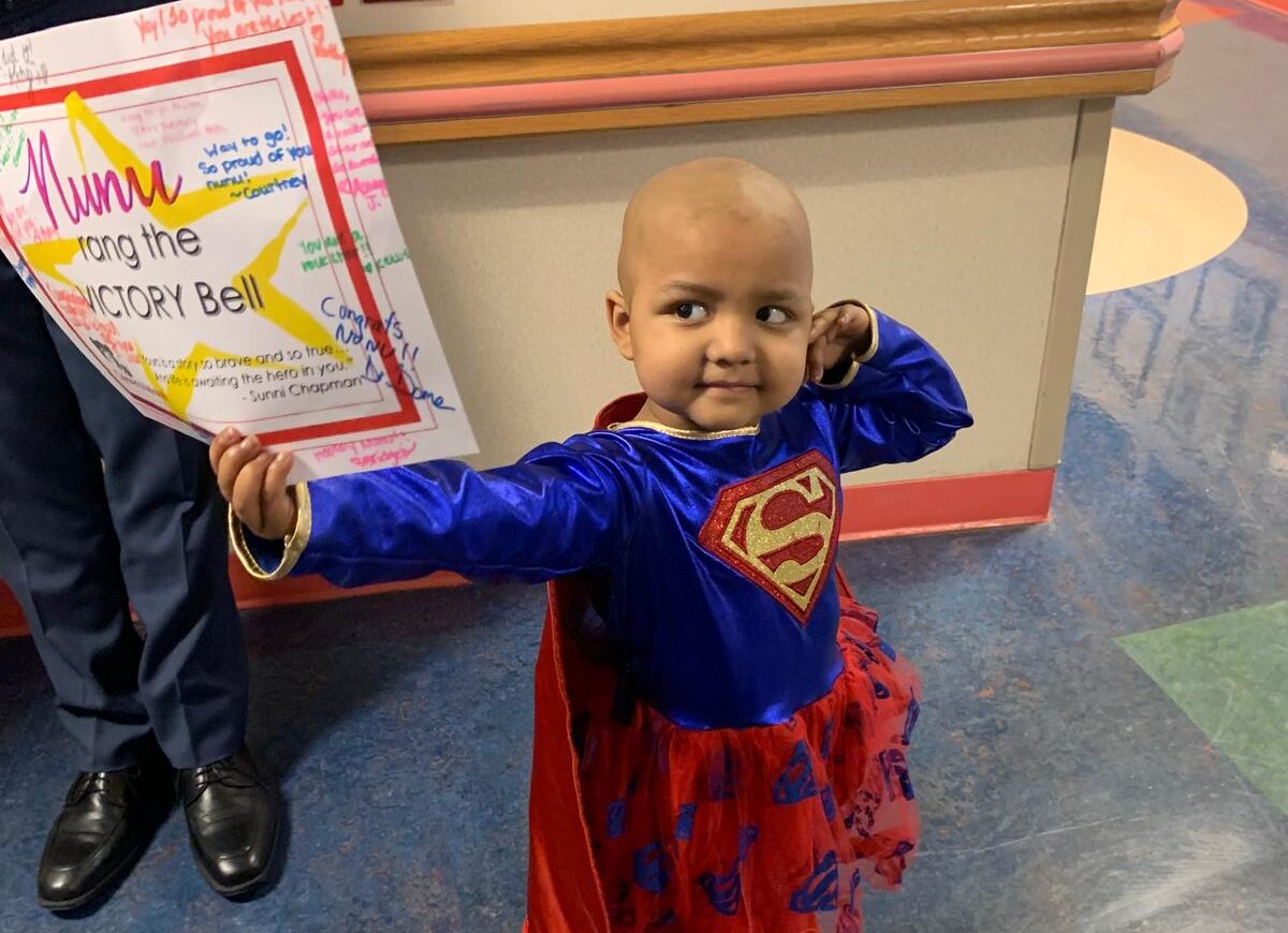 a small child in a superman shirt and red tutu