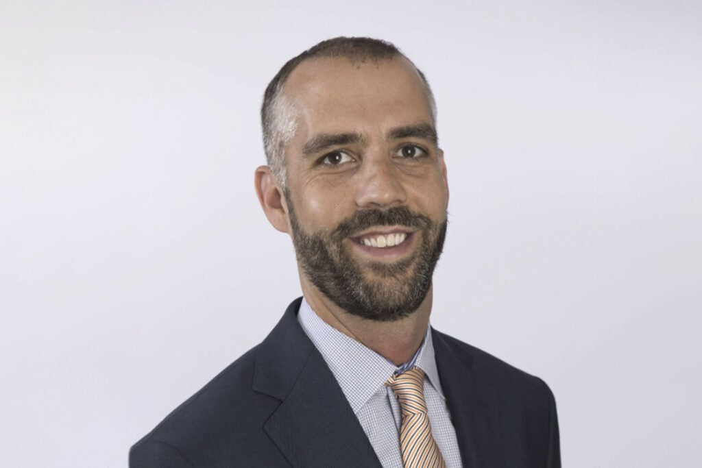 a man in a black suit and gold tie