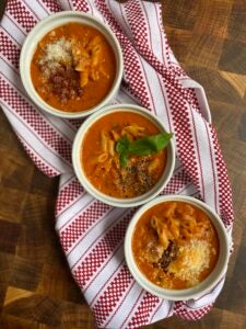 three bowls of soup on a kitchen towel