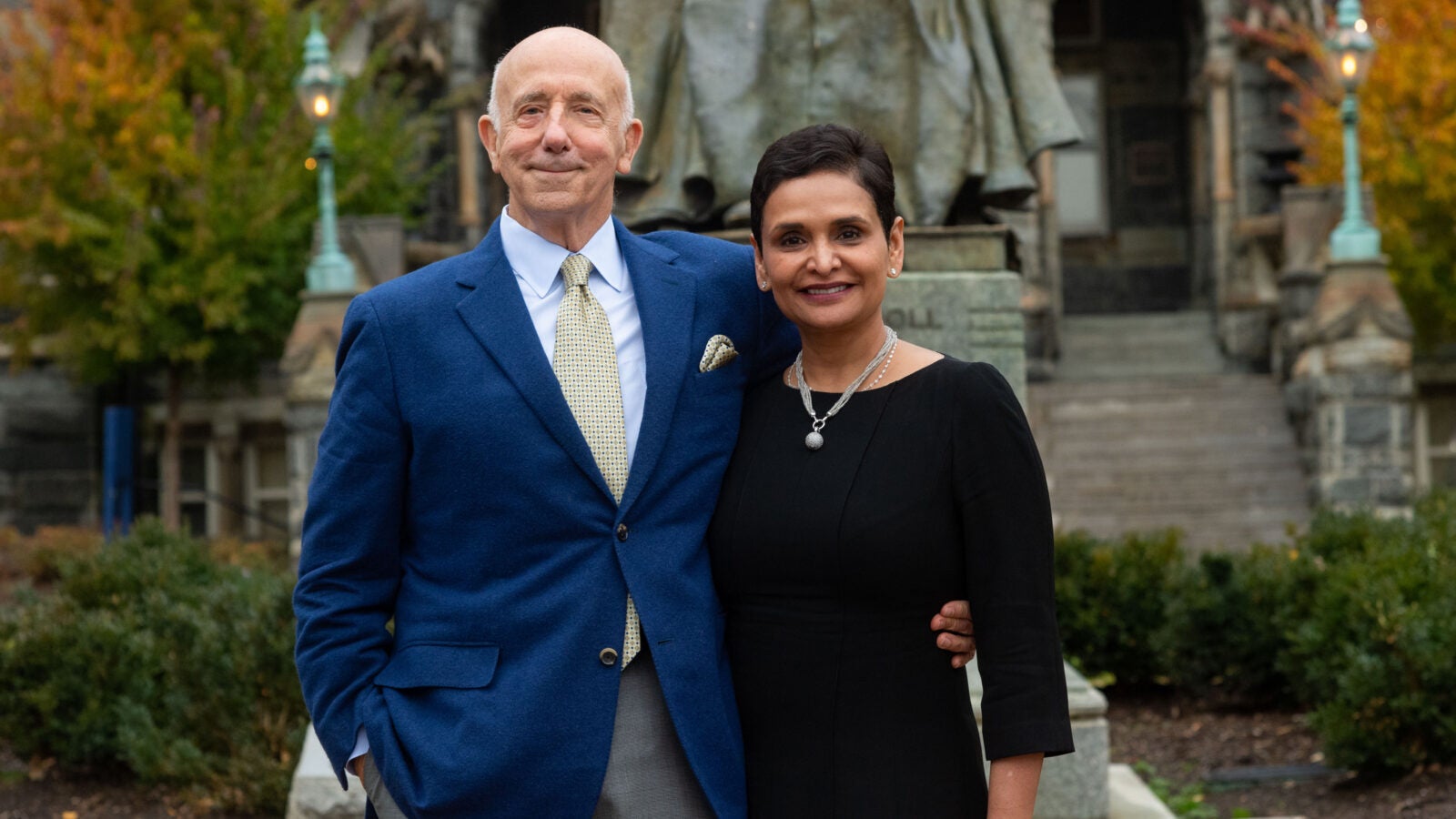 two people stand in front of the John Carroll statue