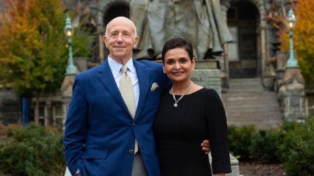 two people stand in front of the John Carroll statue