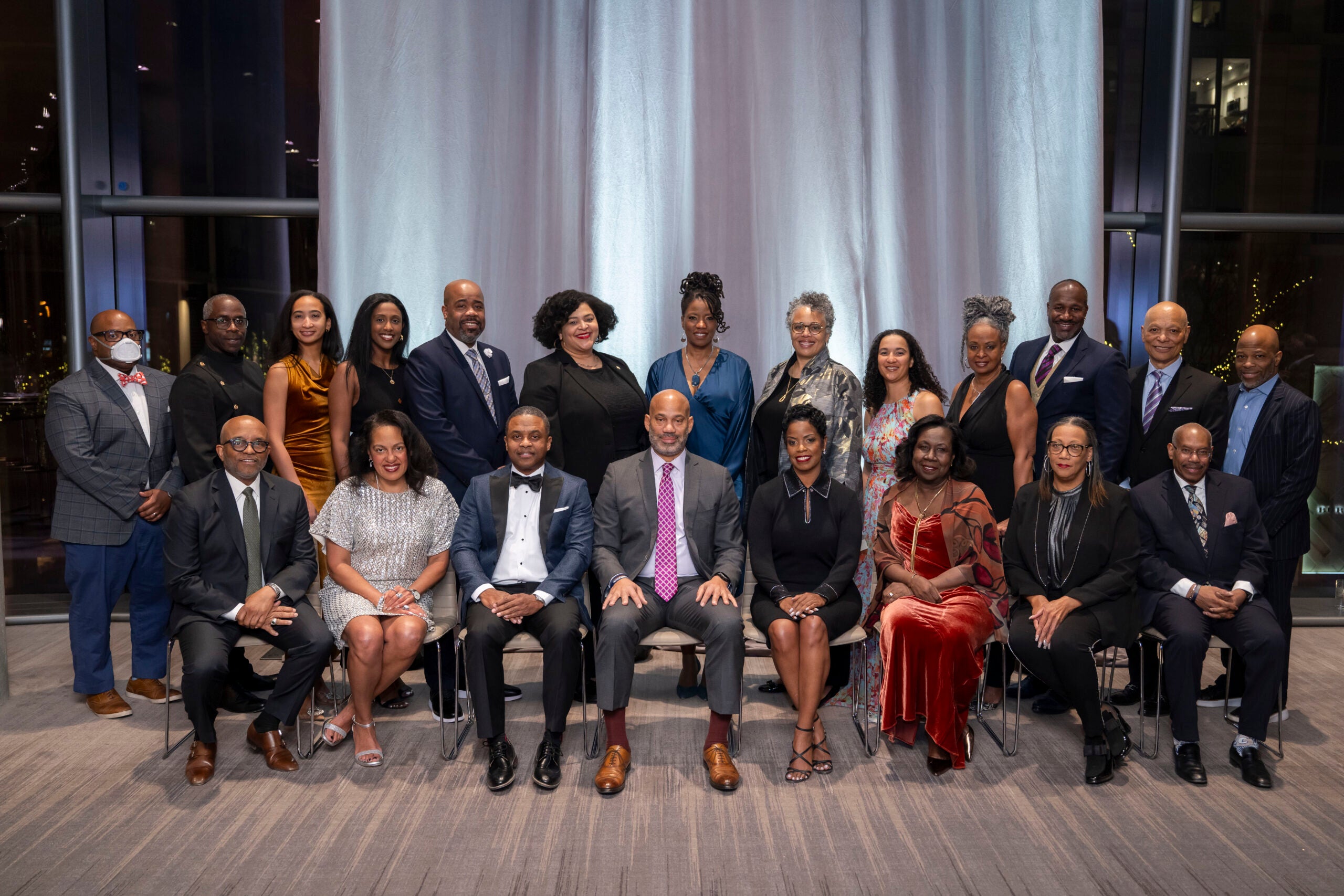 a group photo of two rows of people in formal attire 