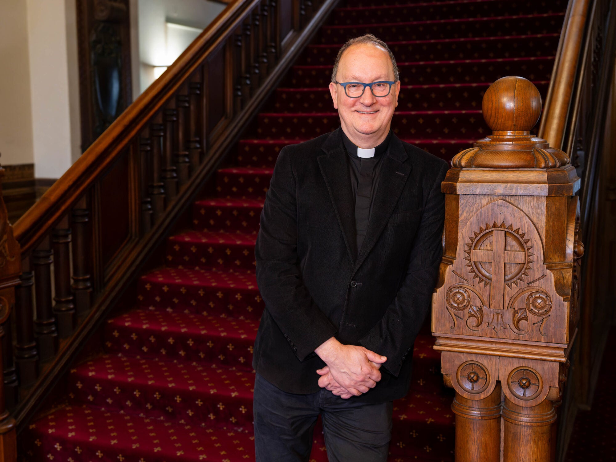 a priest stands at the beginning of a staircase