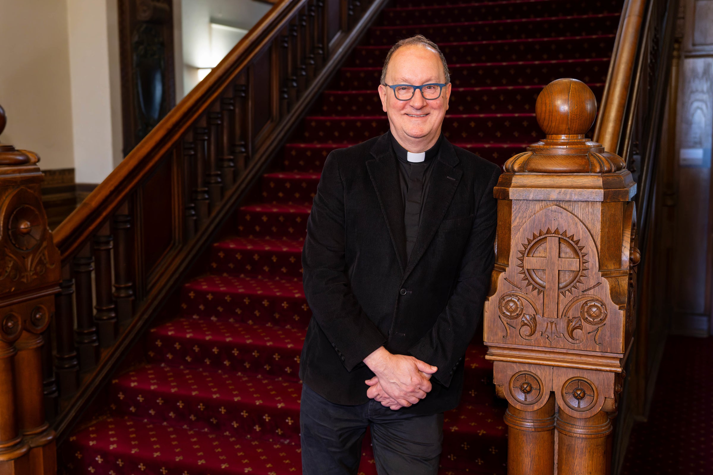 a priest stands at the beginning of a staircase