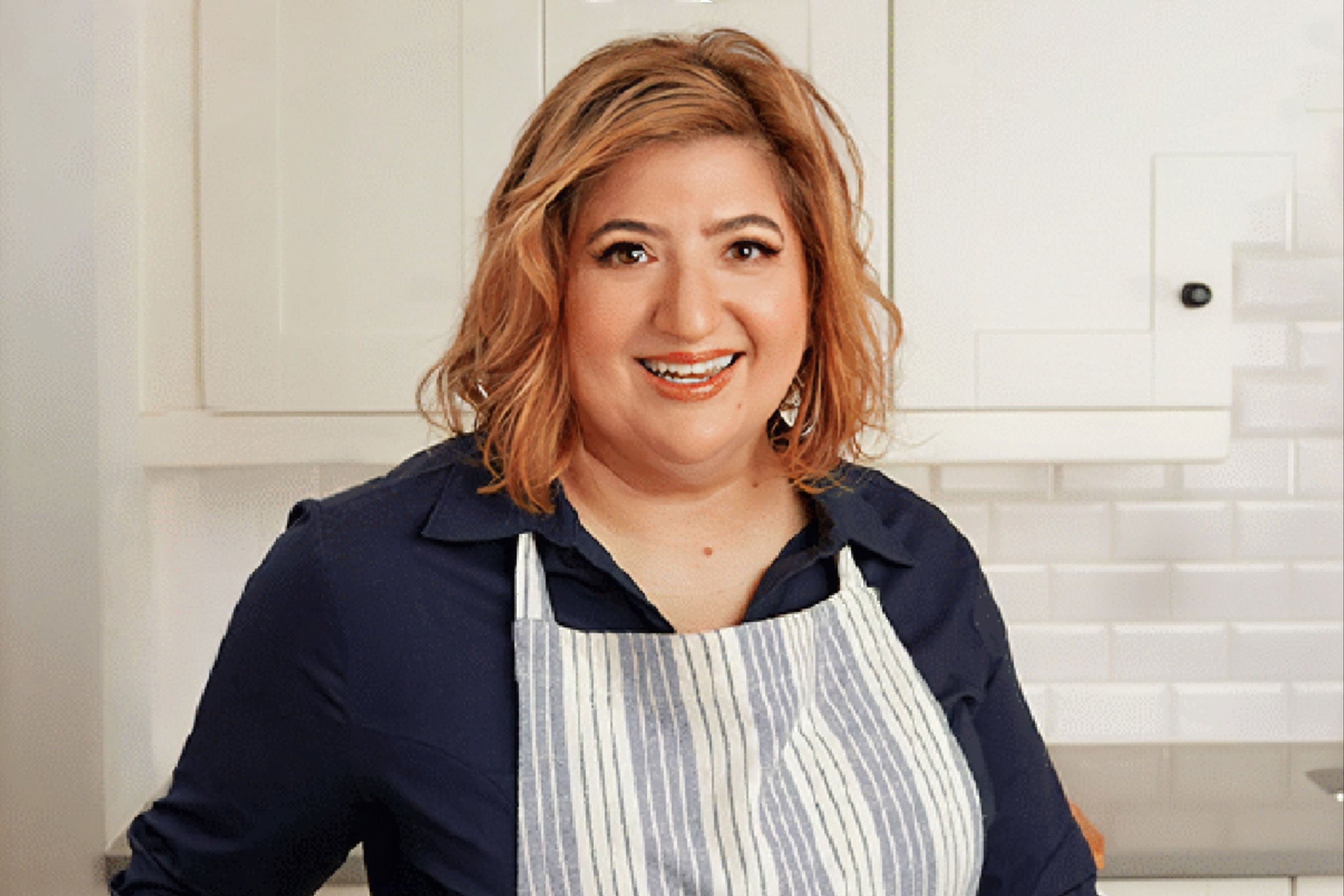 a woman wears an apron in a kitchen
