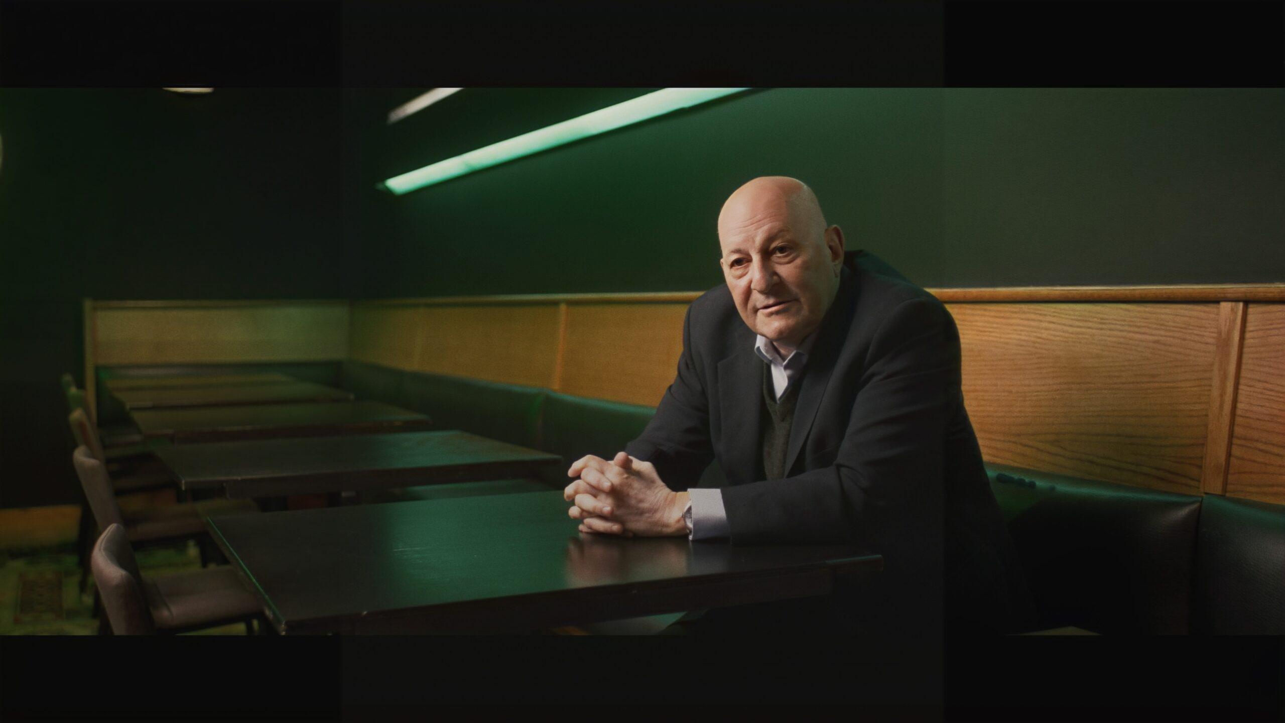 a man in a suit sits at a table