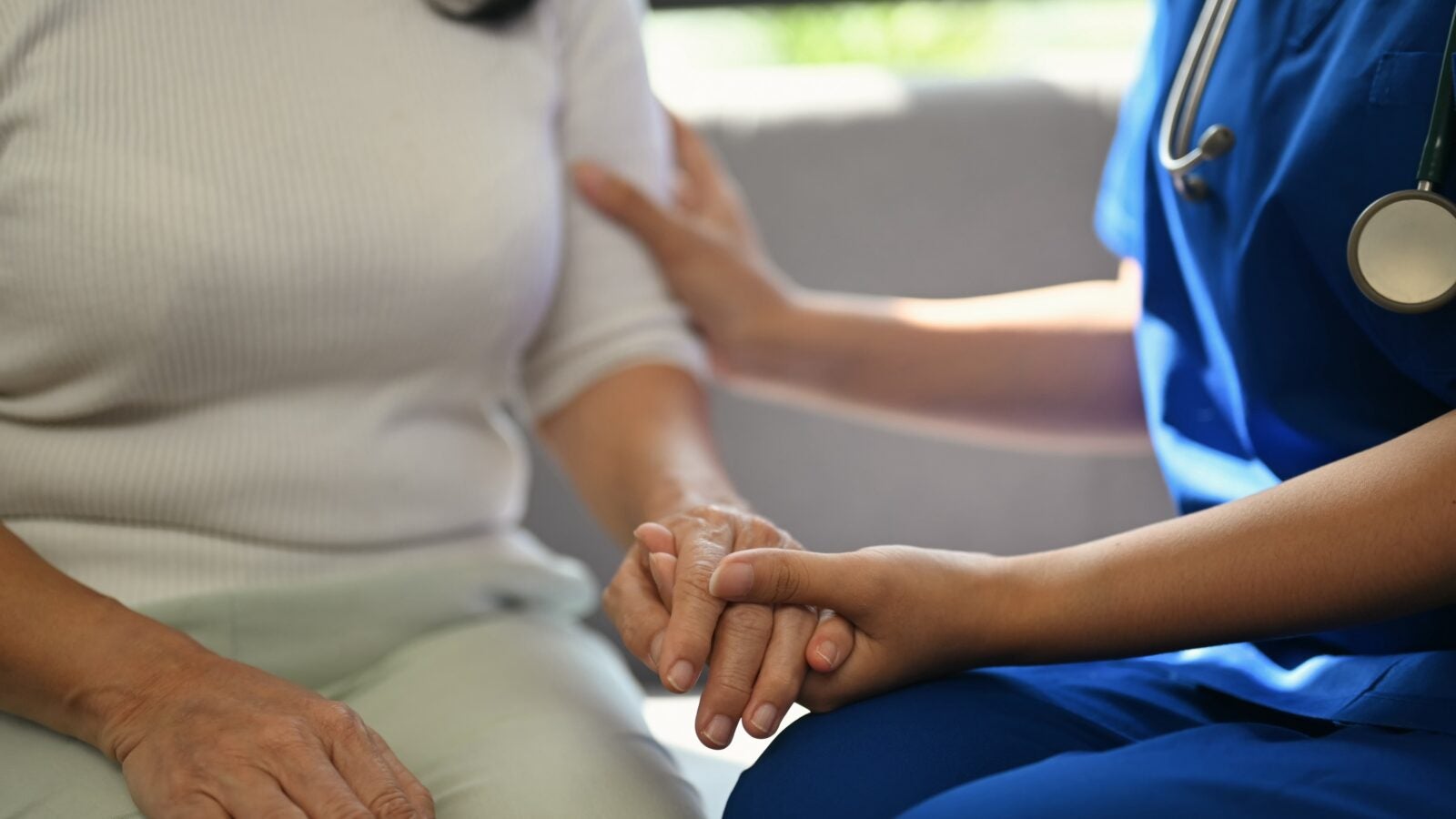 Cropped shot of doctor holding senior woman hand for hope and supporting. Elderly healthcare concept