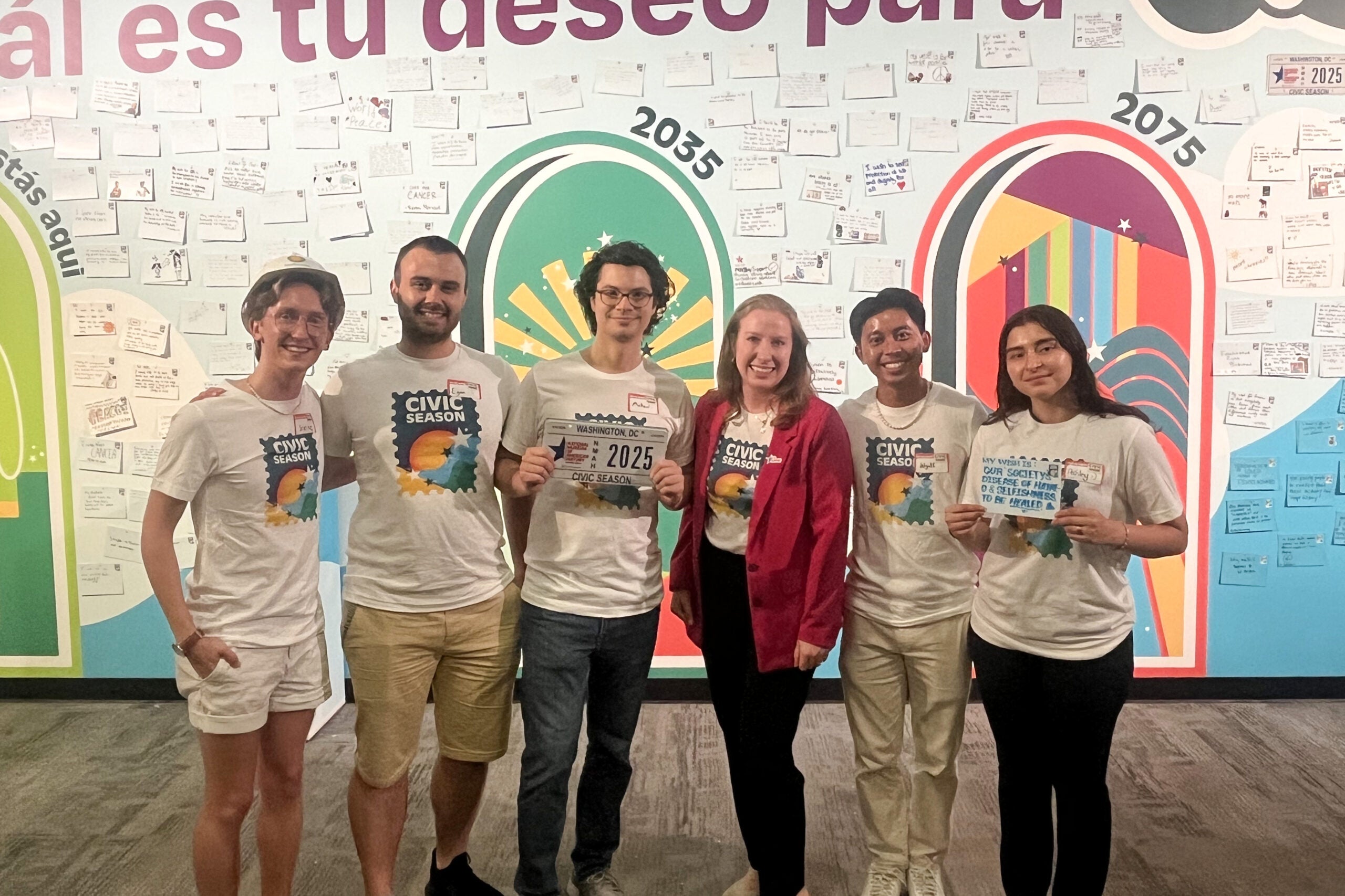 Caroline Klibanoff and her Civil Season team—including fellow Hoyas Joseph “Scottie” Vandy (C’27) and Wyatt Nako (C’26)—celebrate the U.S. 250th celebration in front of the Wish Wall mural at the Smithsonian’s National Museum of American History.