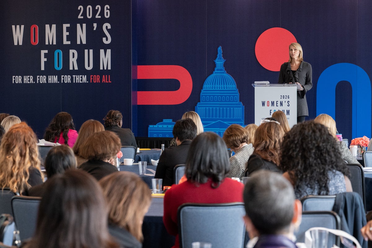 person speaking on stage at women's forum