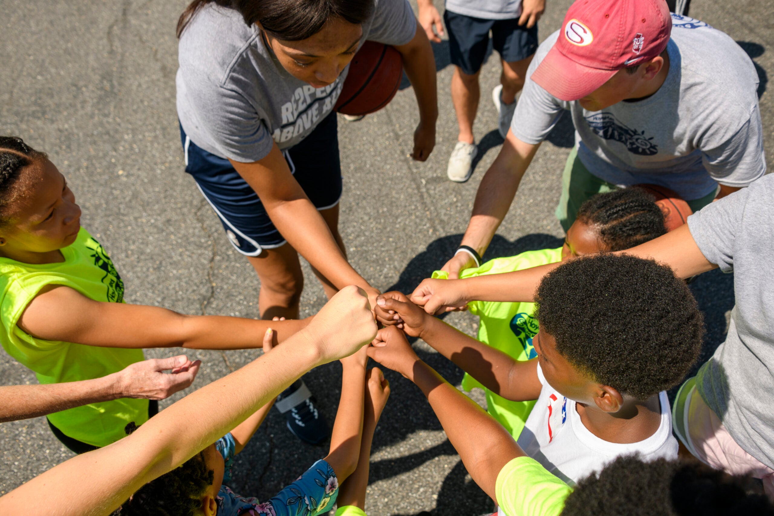 people putting hands into middle in a group