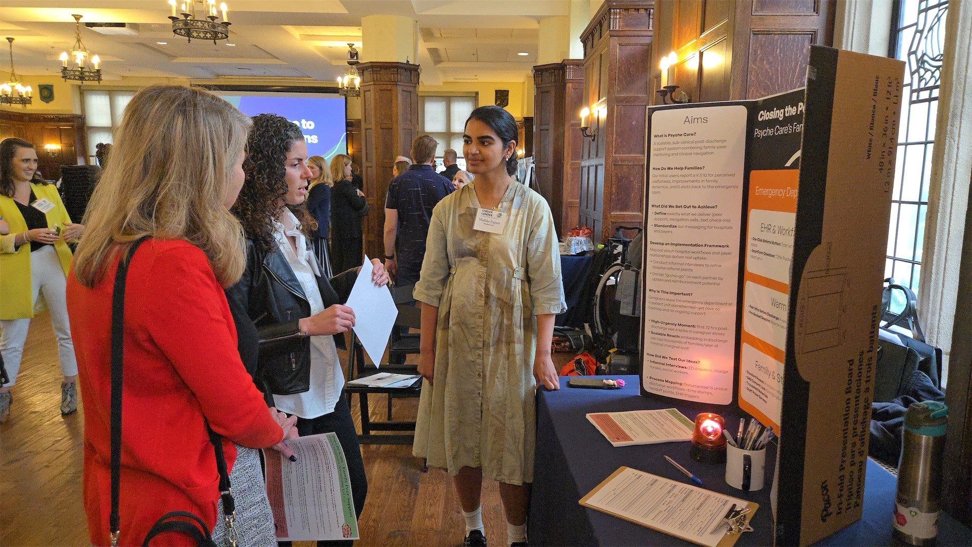 student in poster session presenting to attendees