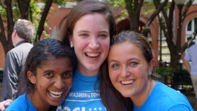 three people in bright blue shirts outside Dahlgren Chapel