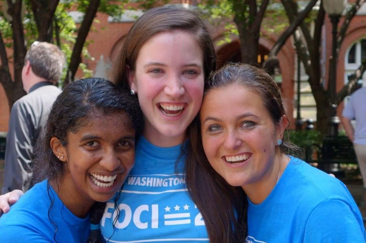 three people in bright blue shirts outside Dahlgren Chapel