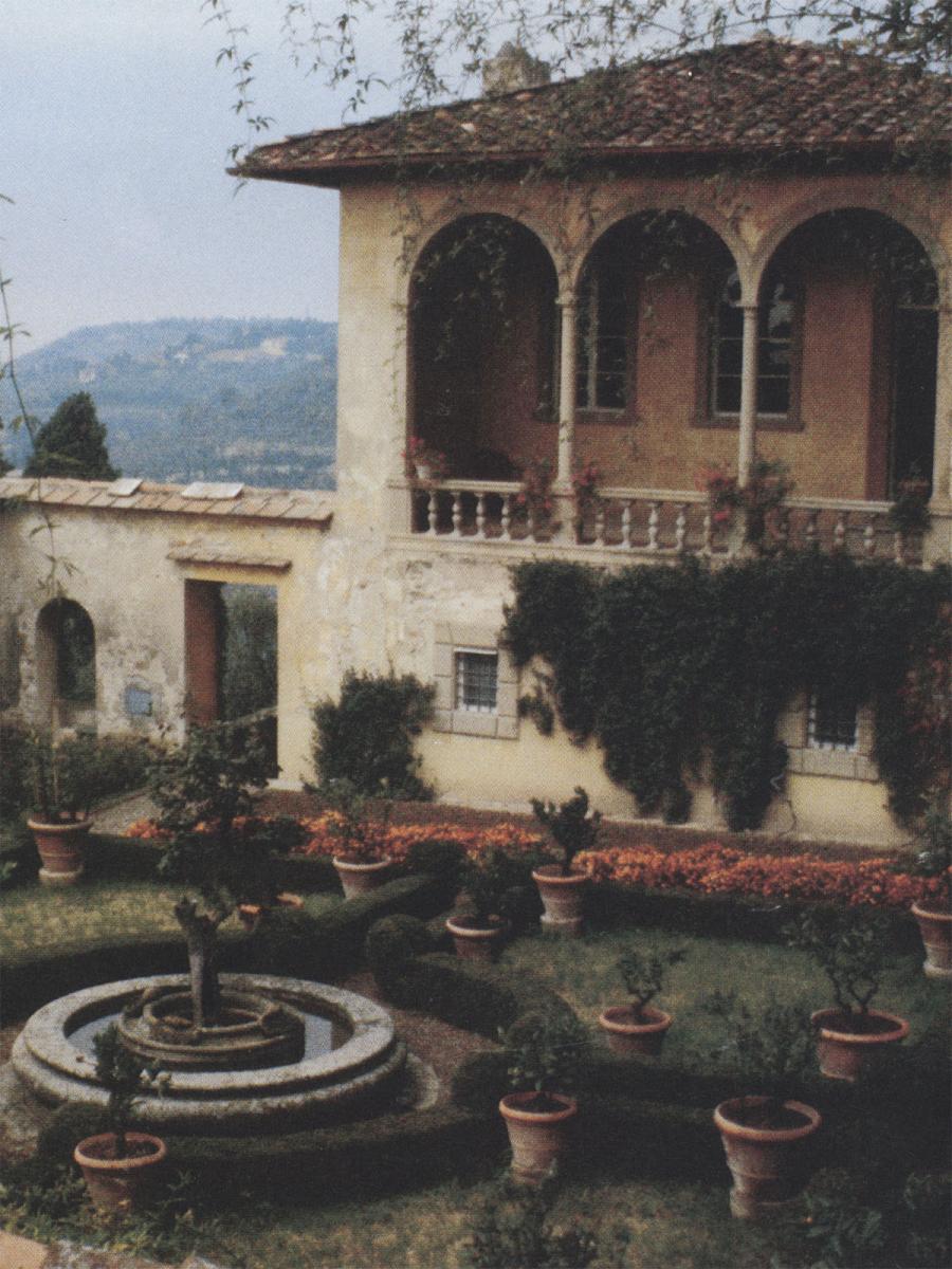 Faded color photo depicting the same courtyard from a mirror angle to the previous image. The courtyard garden contains many small potted plants.