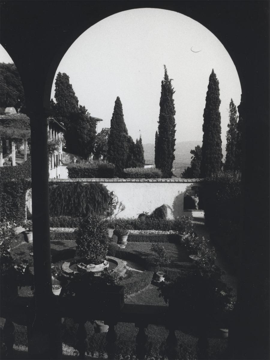 Black and white photo of the same courtyard, from the perspective of the enclosed balcony above.
