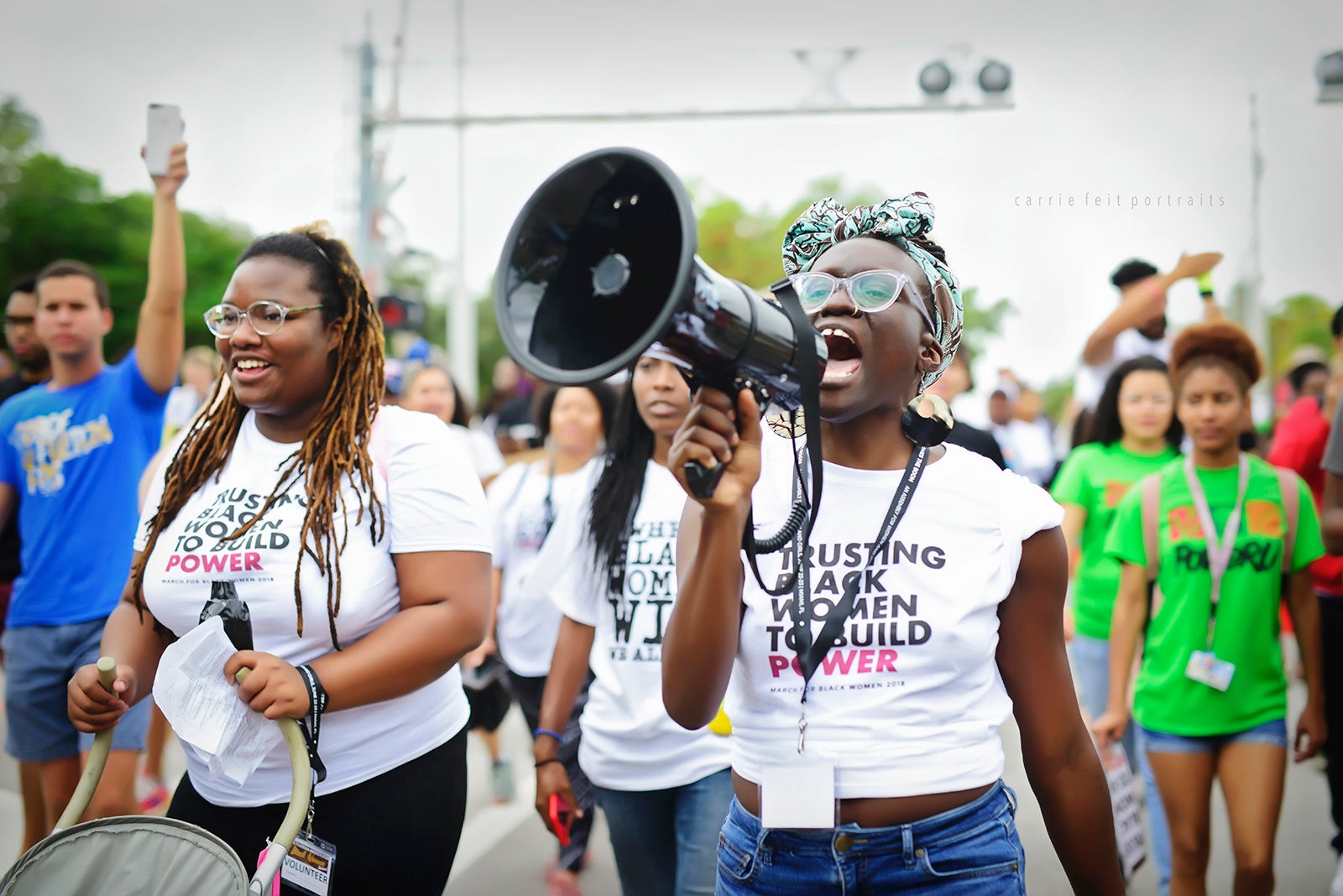 Wakumni Douglas speaking into a bullhorn while marching with others at the 2018 March for Black Women