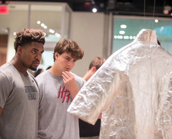 Students take in the beauty and functionality of innovative wearable art made from recycled material. The coat in the exhibition is made from Pinatex, which is non-edible pineapple waste.